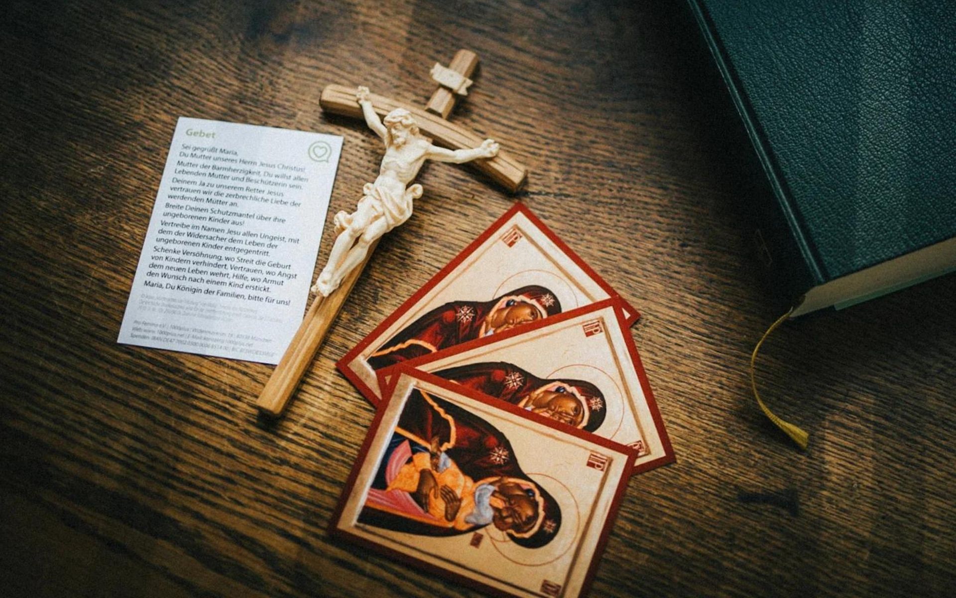 ein Holzkreuz mit Gebetskärtchen zur Mutter unseres Herrn