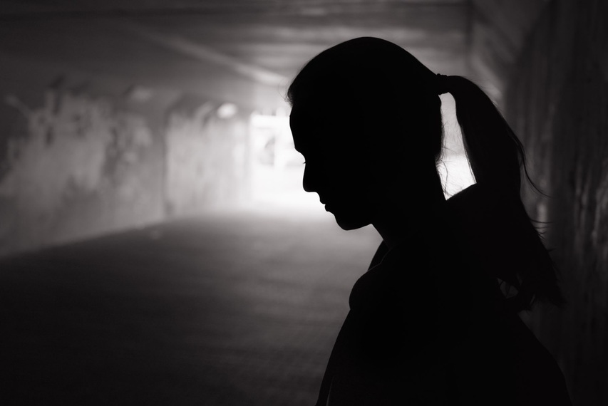 Frauensilhouette in Tunnel schaut nach links